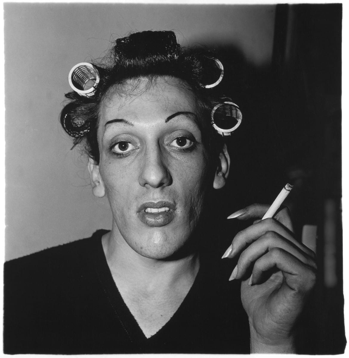 Person with curlers in their hair smoking a cigarette